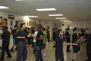 Students during free exercise practicing their forms, conducting partner drills, and working on the wooden dummy